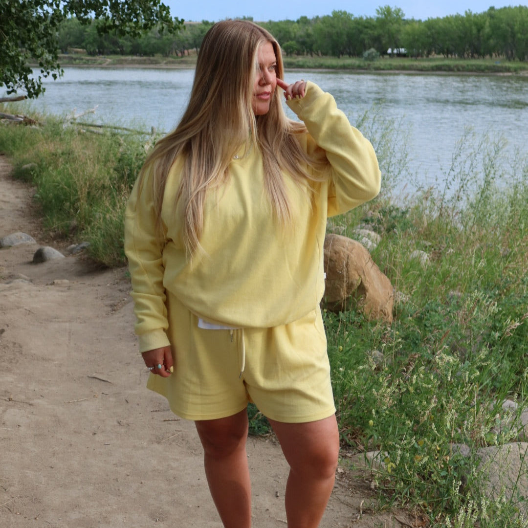 Person wearing a yellow outfit standing by a lake